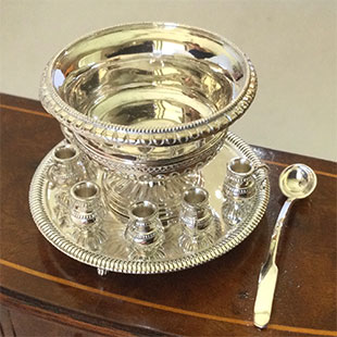 A silver bowl and plate on top of a table.