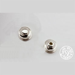 A pair of silver beads sitting on top of a table.