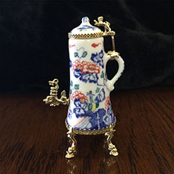 A small vase with a handle and a lid.